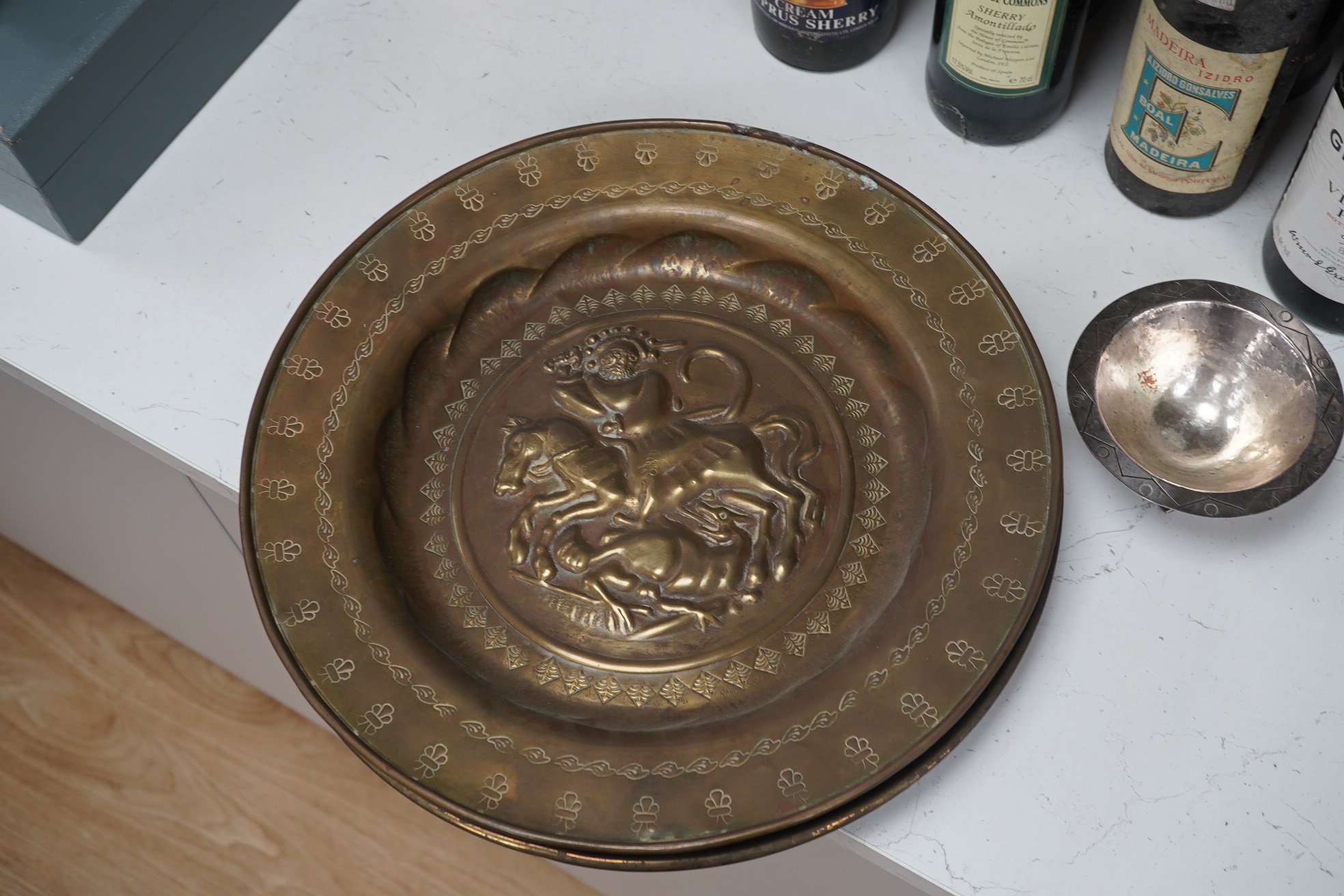 Two Nuremberg style embossed brass alms dishes and a Dresser style silver plated three footed bowl, brass dishes 36cm diameter. Condition - good